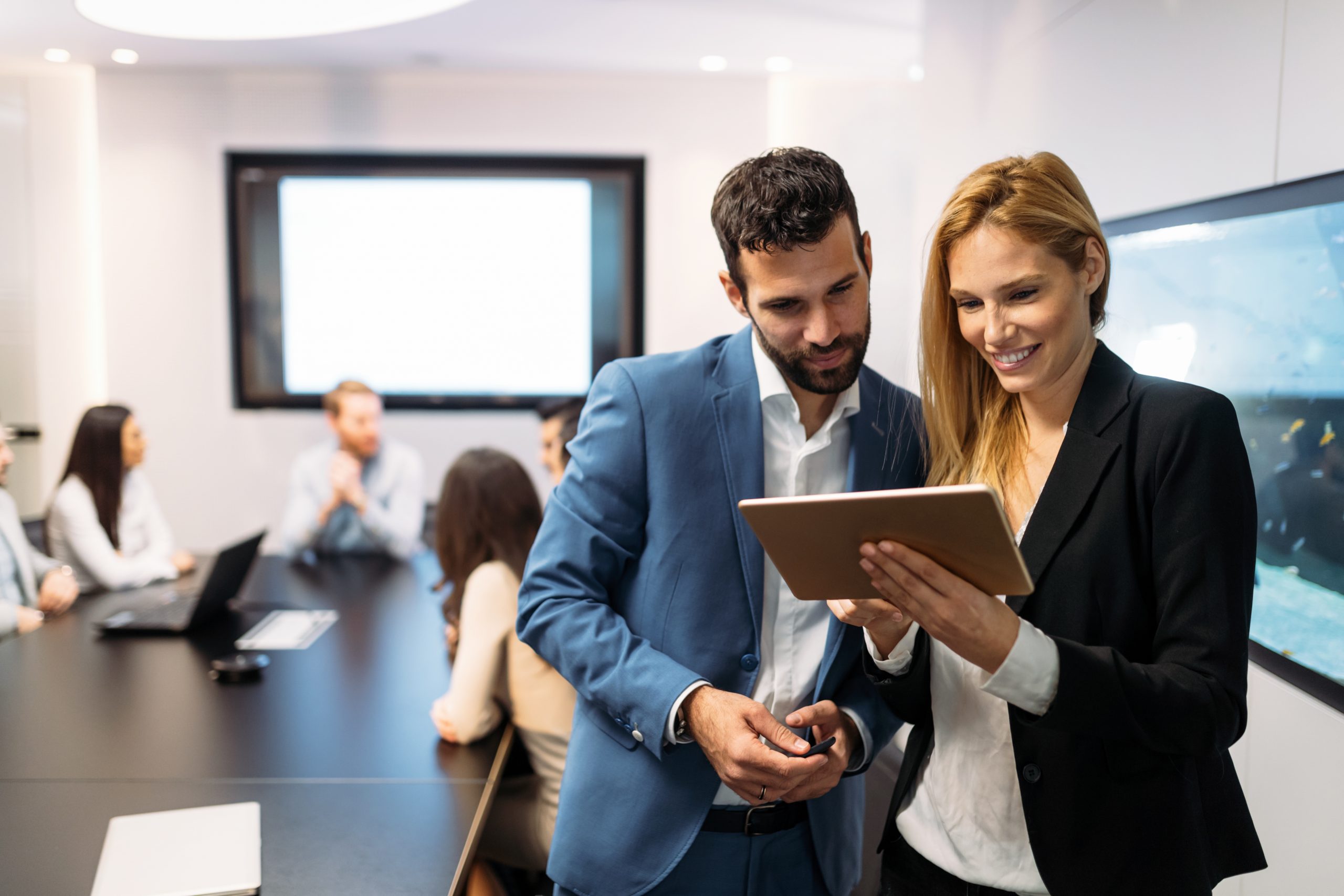 Businesspeople discussing while using digital tablet in office together