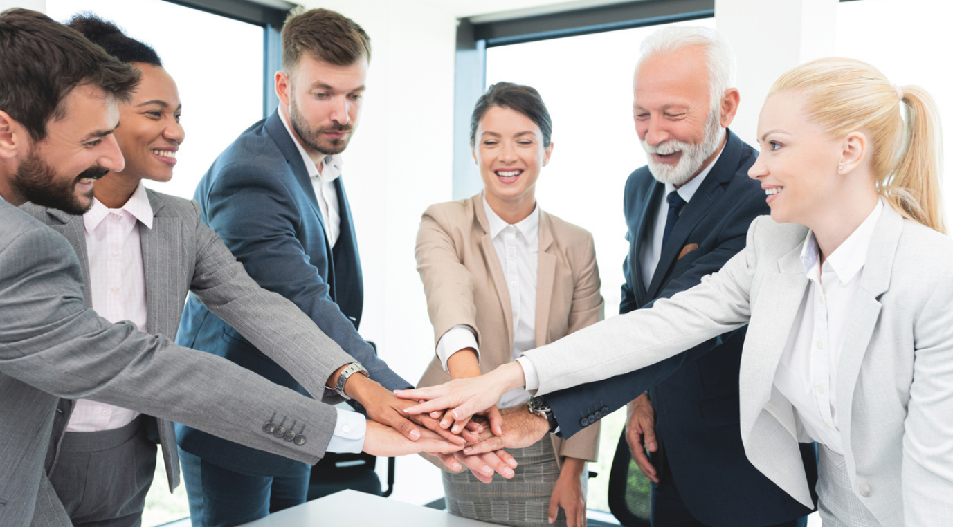 Fünf Leute, welche sich im Kreis die Hand reichen